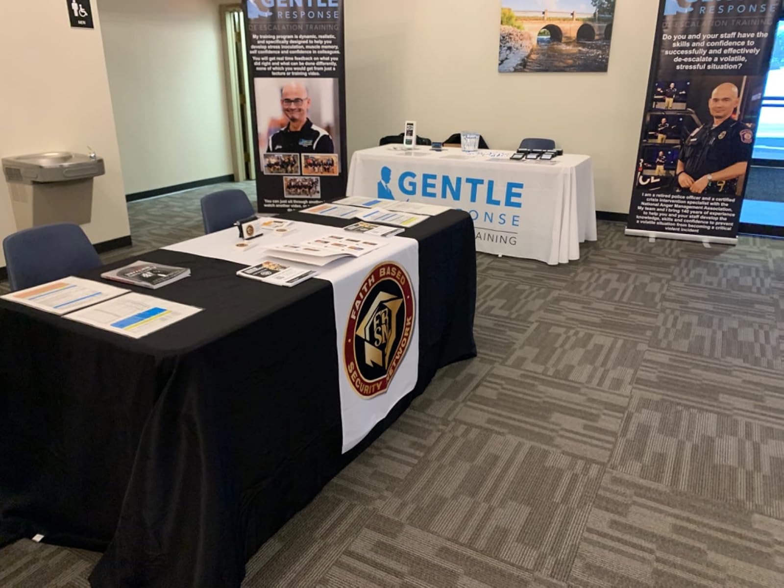 Trade show booth with branded table runners and promotional materials on display